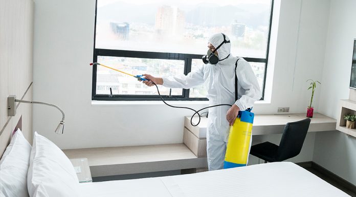 Hotel worker cleaning in PPE - 944x522