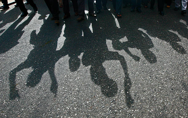 Protesters cast a shadow as they march on a street